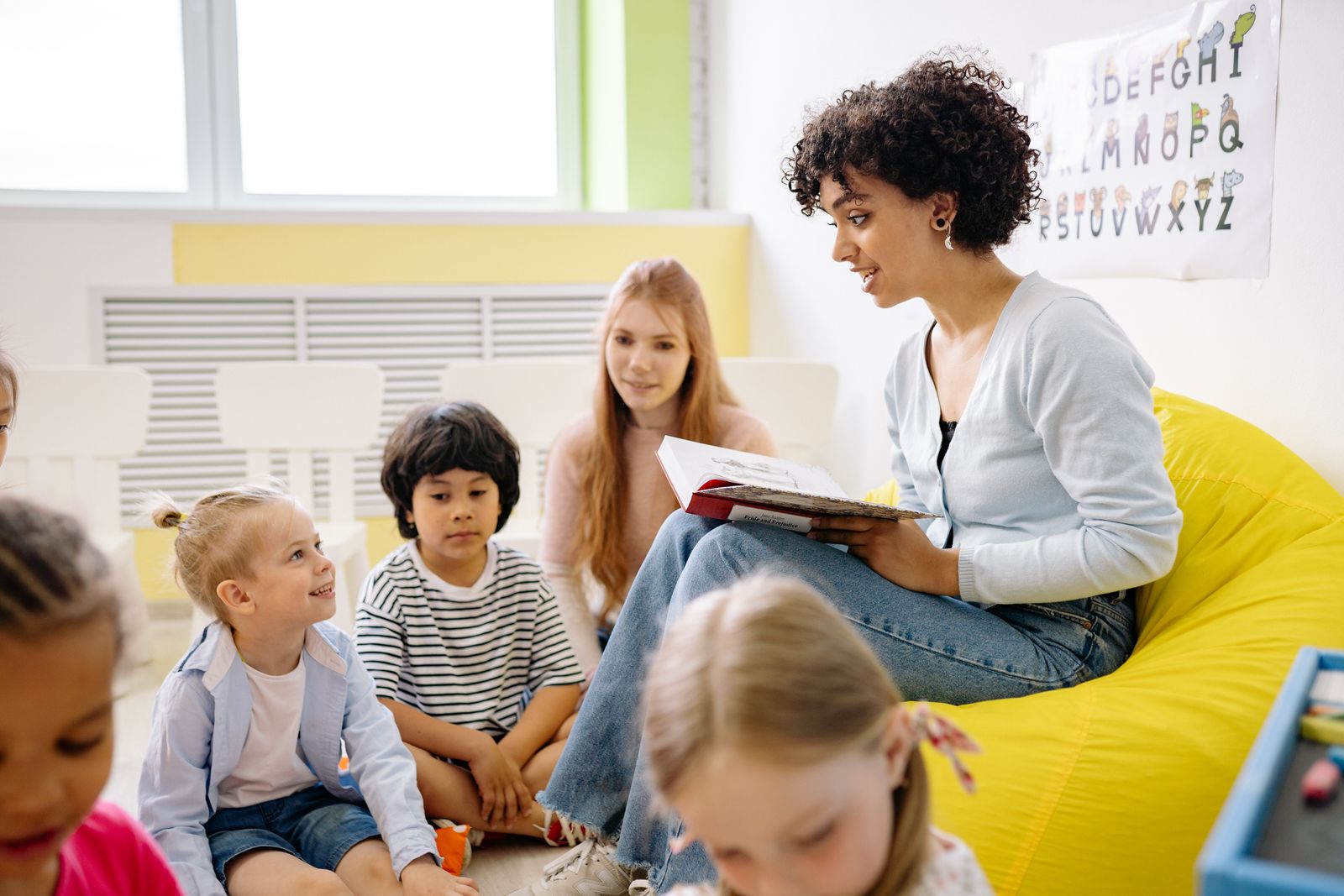 A teacher reading a picture book to a group of young children